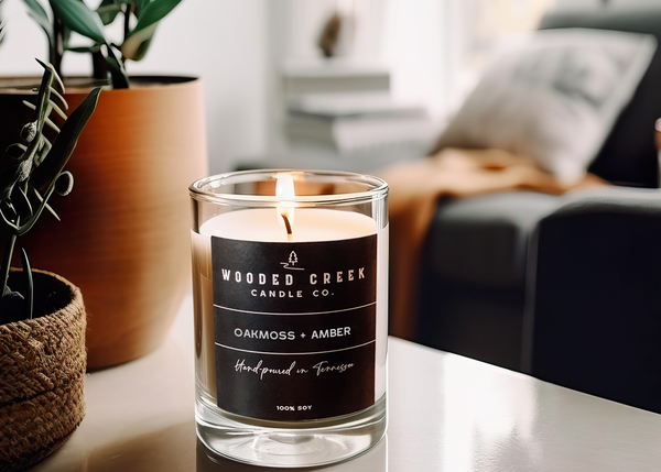 Oakmoss + Amber candle displayed on a table