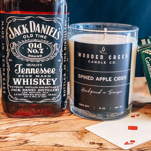 Spiked Apple Cider displayed with whiskey and apple cider candle
