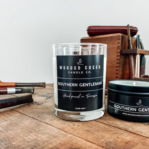 Southern Gentleman candle displayed beside a wooden table