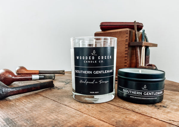 Southern Gentleman candle displayed beside a wooden table