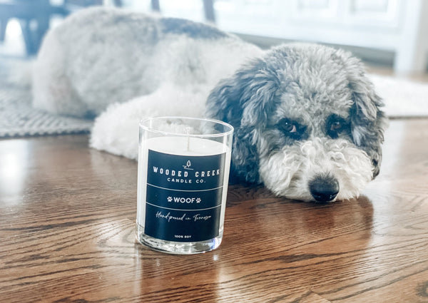 "Woof" product image showing a dog lying near a candle
